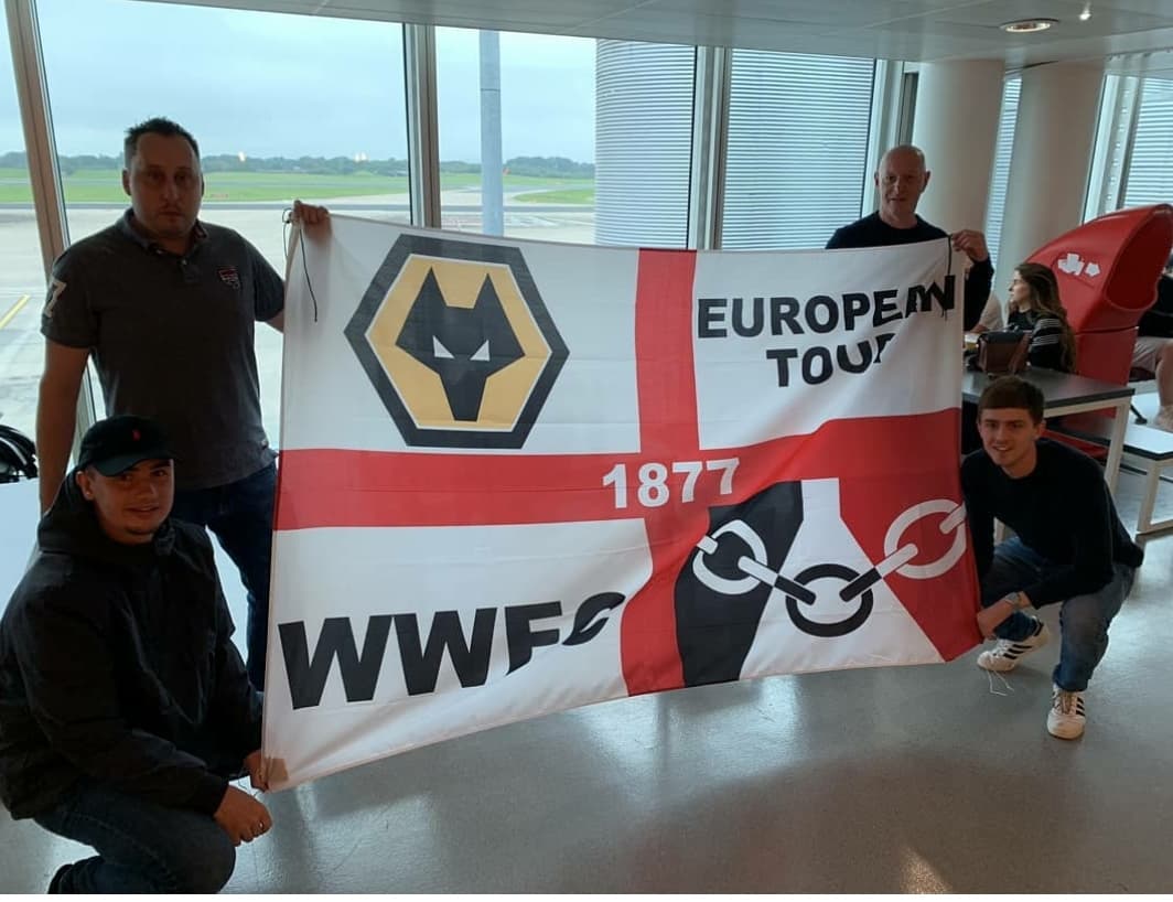 Supporters travelling with a personalised European football tour flag