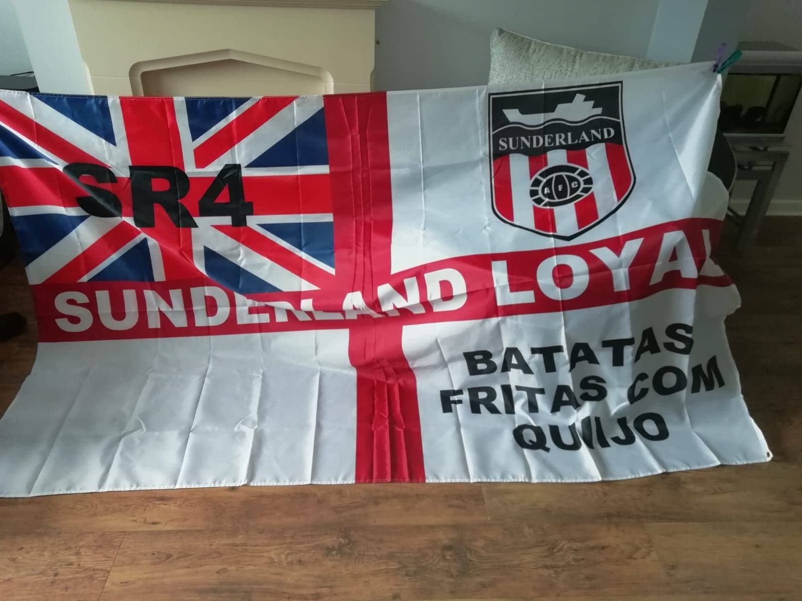 Supporters displaying a large custom red and white football flag
